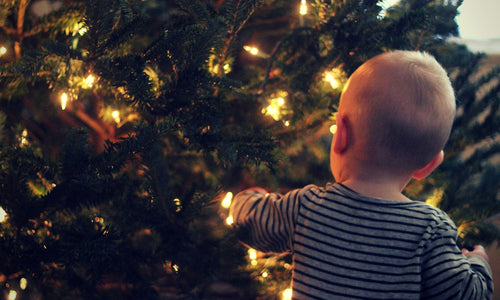 Little baby in front of a Christmas tree 