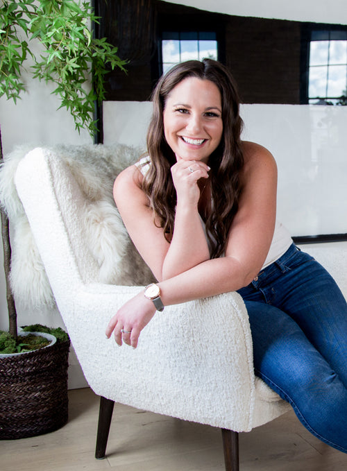 Owner of Bundled - Alicia McClure - sitting on a chair smiling. Discover sustainable, affordable, gently-loved children's clothing bundles at Bundled, supporting parents and the environment with curated, high-quality options for newborns to toddlers at affordable and cheap price points.