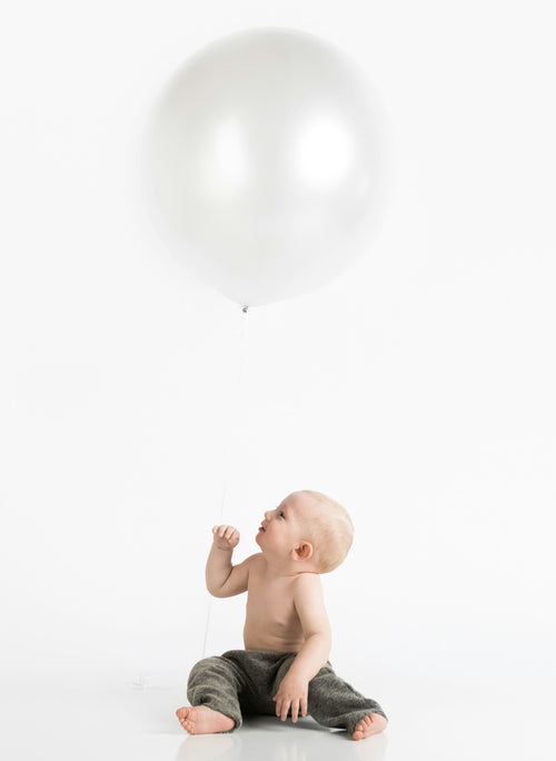 Little boy holding onto a balloon. Discover sustainable, affordable, gently-loved children's clothing bundles at Bundled, supporting parents and the environment with curated, high-quality options for newborns to toddlers at affordable and cheap price points.